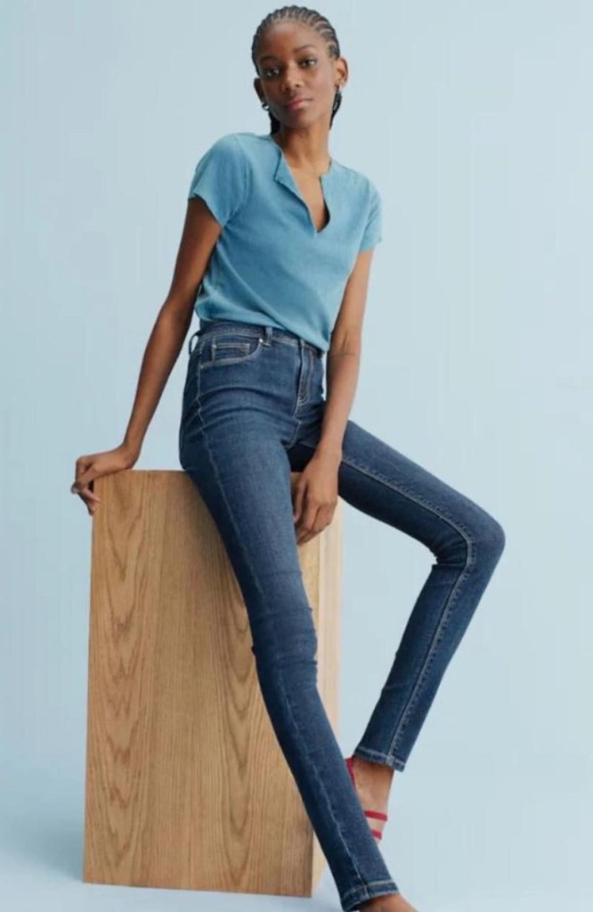 Nicole McCloud wearing denim leggings with dark blue power while sitting in a block